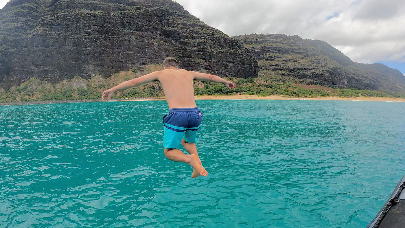 na-pali-coast-swim-1.jpg Passenger jumping from the tour raft into turquoise water below the Na Pali cliffs