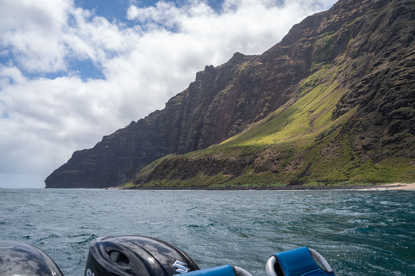 na-pali-coast-cliffs.jpg Sunlit green slope beneath the layered cliffs of the Na Pali Coast