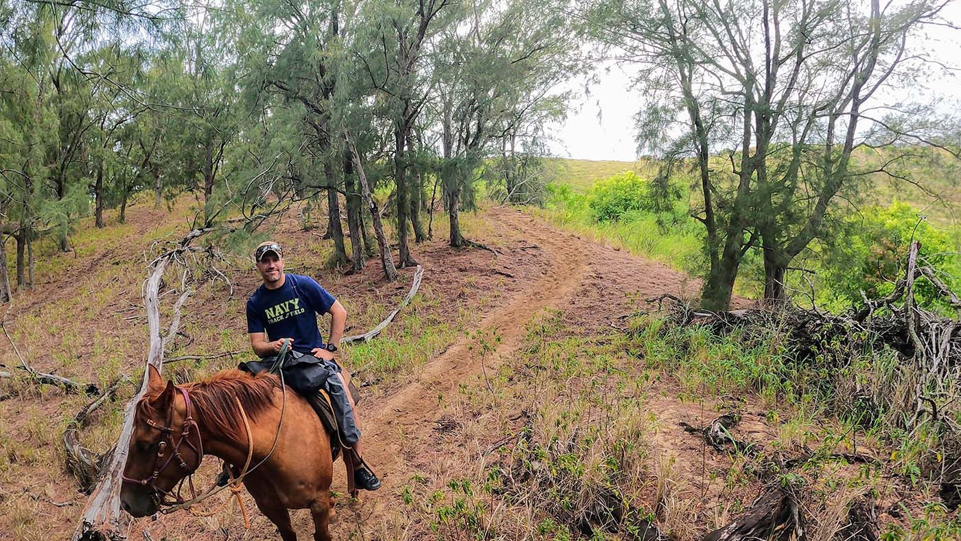 kauai-horseback-riding-forest-2.jpg Mike riding Gus on a sandy trail through the trees
