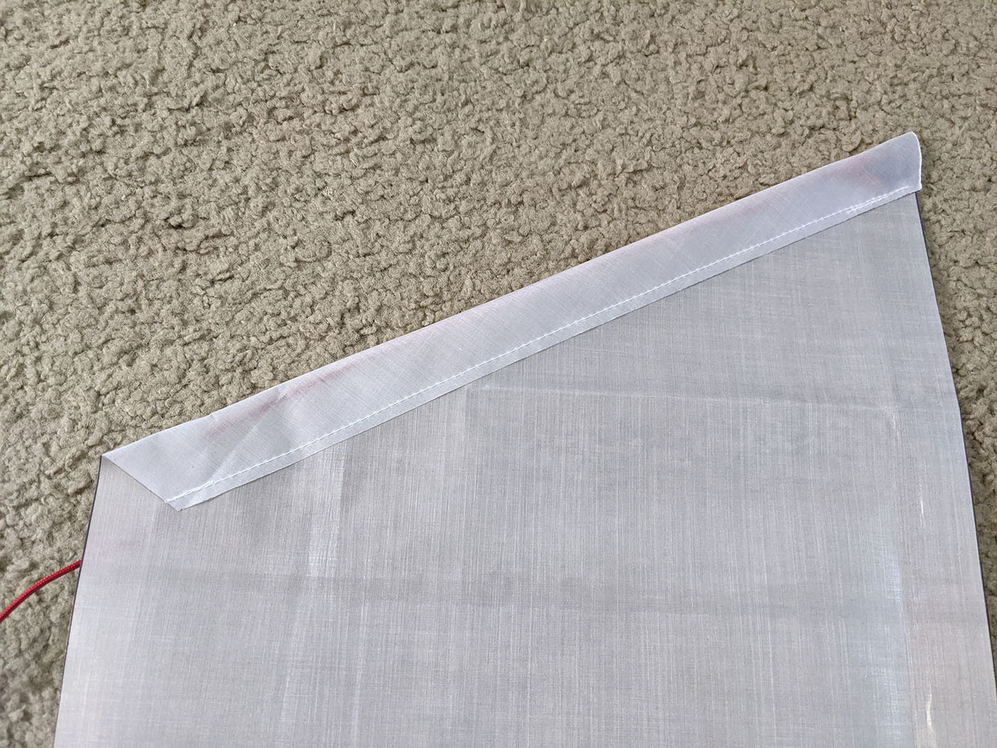Hemmed angled top edge of a white Dyneema side pocket