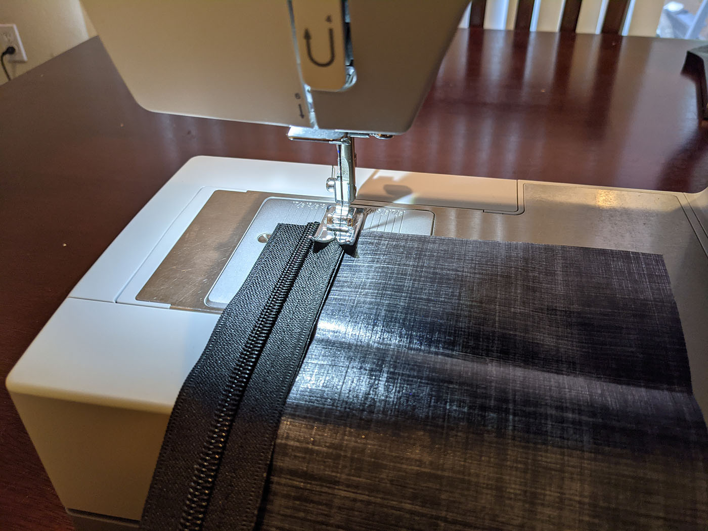 Sewing the full-length zipper onto the black Dyneema back panel
