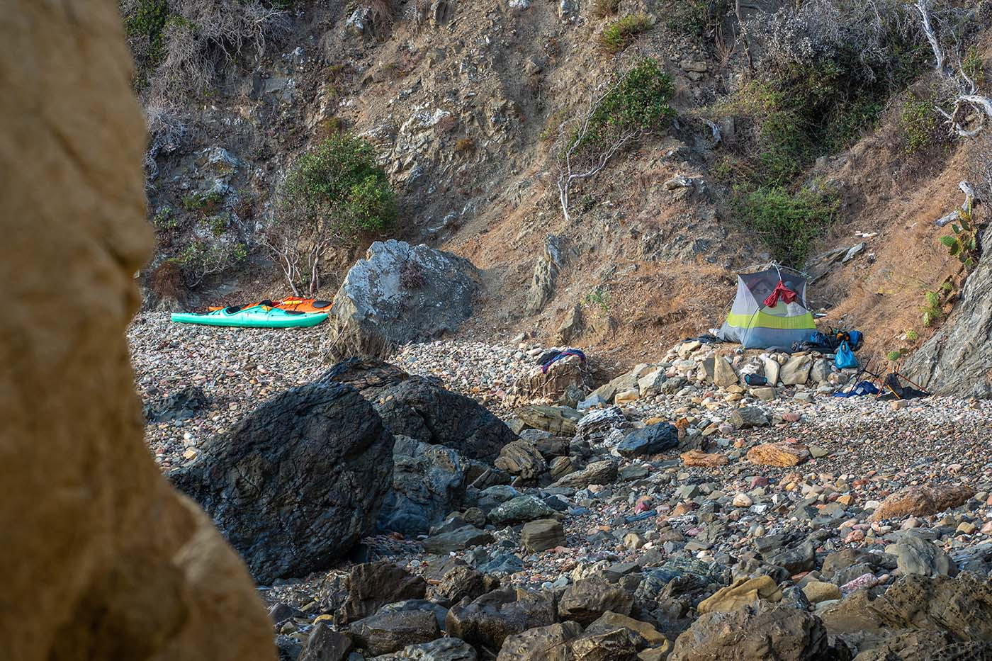 Tent and two kayaks spread across the rocky Italian Gardens 4 beach