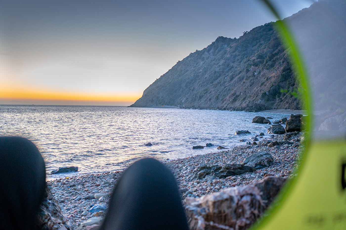 Sunset over the rocky Catalina coast viewed from inside the tent